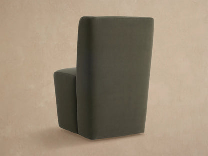 Close-up of Lina Outdoor Dining Chair in dark gray-green fabric, showing upholstered back and seat, angled view.