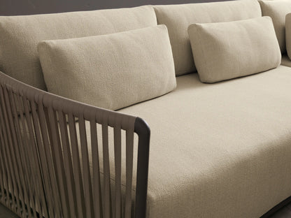 Lisbon Outdoor Two-Piece Sectional, L-shaped with light cream cushions, dark brown woven rope arms on a stone patio.
