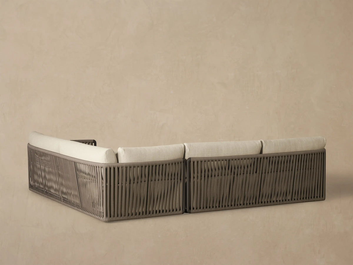 Lisbon Outdoor Two-Piece Sectional, light beige cushions & lumbar pillows, dark brown woven rope armrest, close-up.