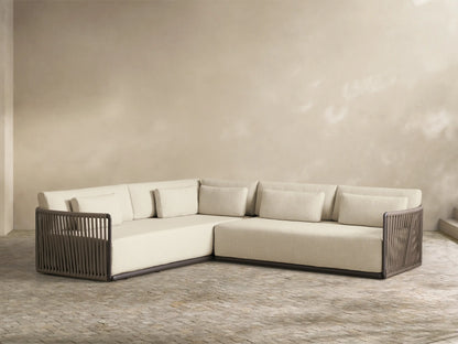 Lisbon Outdoor Two-Piece Sectional with cream cushions and dark rope frames in an outdoor living space with a coffee table.