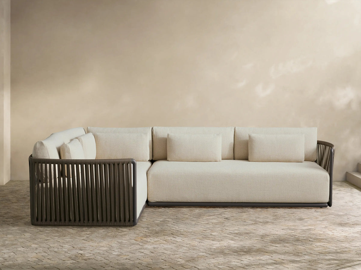 Lisbon Outdoor Two-Piece Sectional, L-shaped, with light beige cushions and dark brown vertical woven rope frame on a patio.