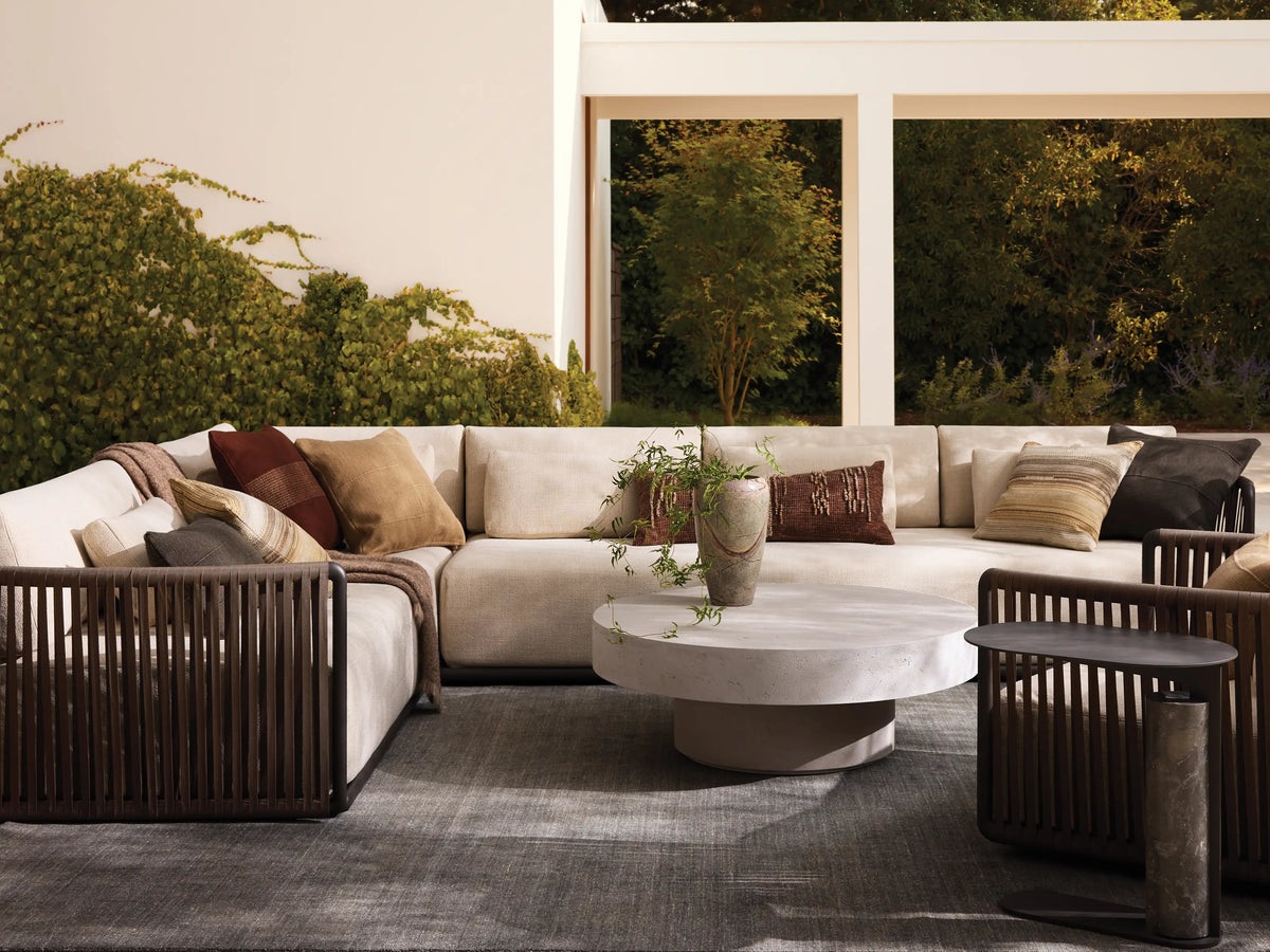 Lisbon Outdoor Two-Piece Sectional, L-shaped, with light beige cushions and dark brown vertical woven rope frame on a patio.