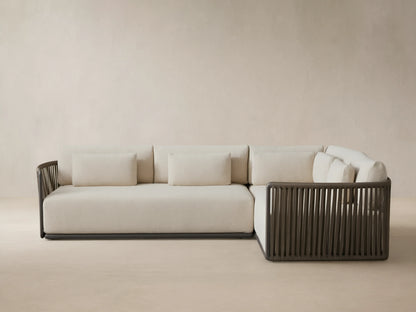 Lisbon Outdoor Two-Piece Sectional, L-shaped, with light beige cushions and dark brown vertical woven rope frame on a patio.