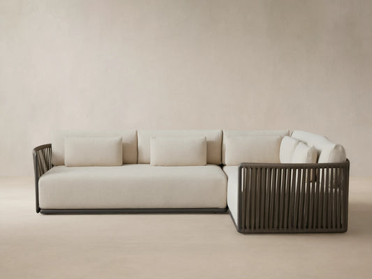 Lisbon Outdoor Two-Piece Sectional, L-shaped, with light beige cushions and dark brown vertical woven rope frame on a patio.
