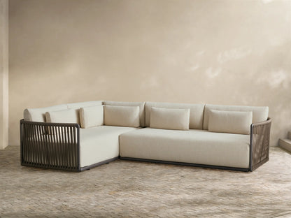 Angled front view of beige Lisbon Outdoor Two-Piece Sectional with dark brown woven frames, plush cushions, and accent pillows on a patio.