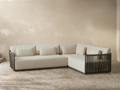 Front view of the L-shaped light beige Lisbon Outdoor Two-Piece Sectional, featuring dark brown woven rope details and accent pillows.