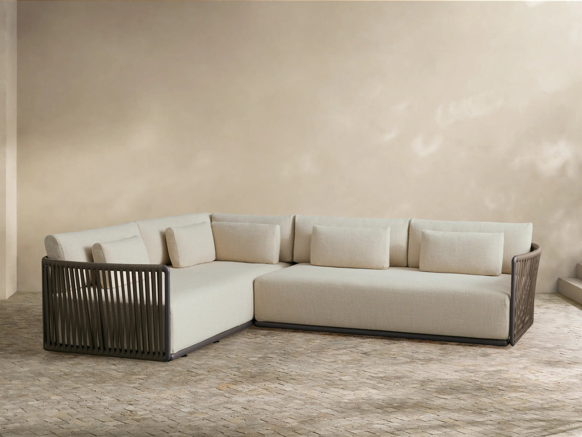 Lisbon Outdoor Two-Piece Sectional with natural cushions and dark brown woven frames, accented with pillows.