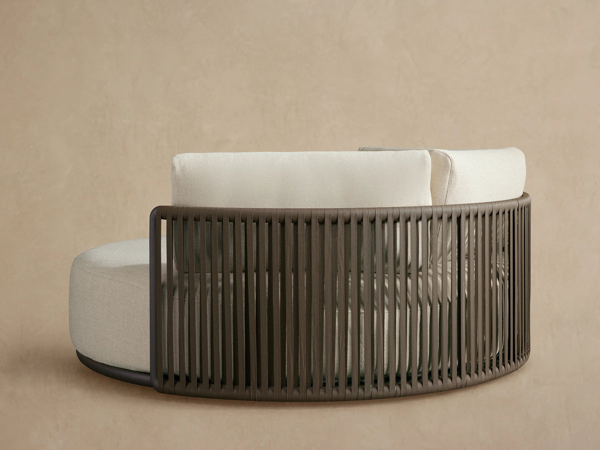 Close-up of Lisbon Outdoor Daybed with dark brown woven rope side and light beige textured seat and back cushions.