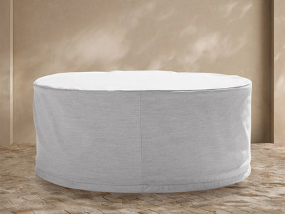 White Pompeii Outdoor Collection Covers tailored for a sofa, chair, and rectangular table, on a stone patio against a tan wall with plants.