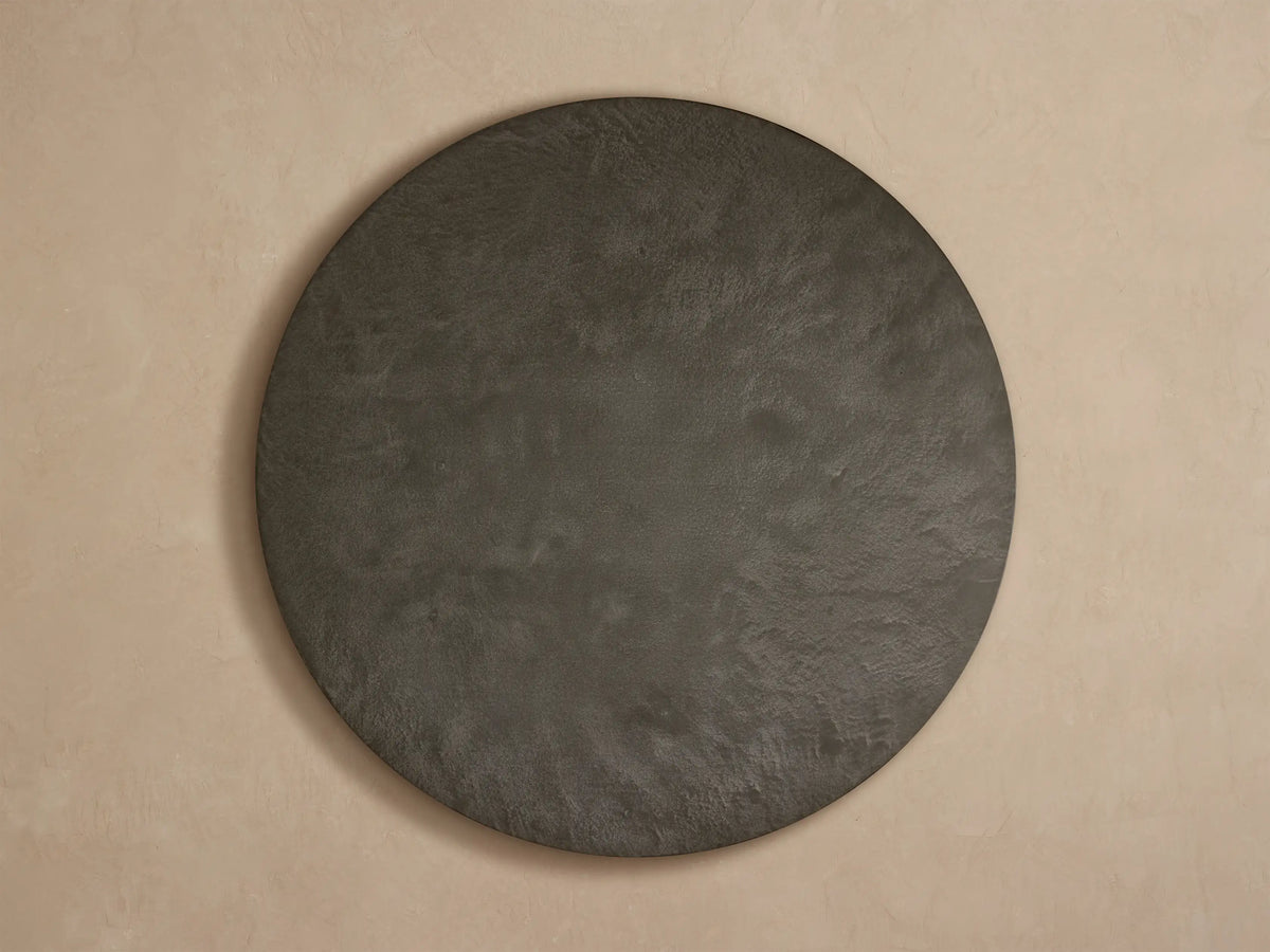 Close-up, angled view of Pompeii Outdoor Round Coffee Table with dark gray concrete top and vertically slatted teak wood base.