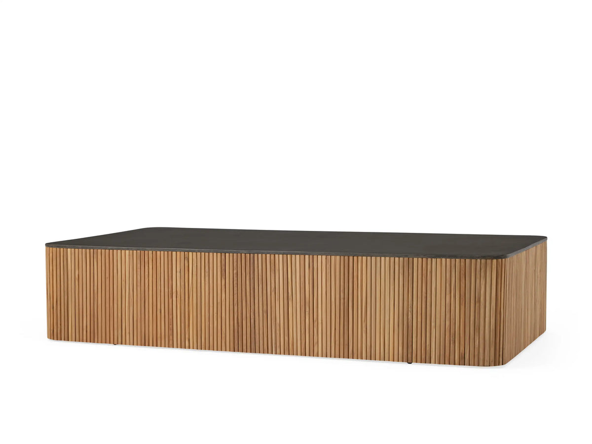 Pompeii Outdoor Coffee Table with a rectangular black concrete top and vertically grooved natural teak wood sides.