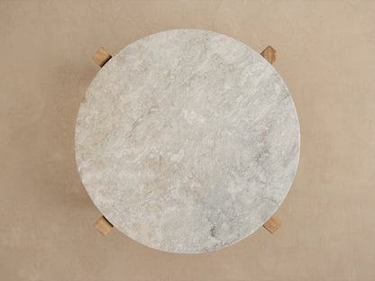 Mari Outdoor End Table, angled view. Round, veined grey marble top on sturdy light brown teak wood legs.