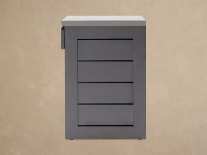 Dark gray aluminum outdoor kitchen cabinet with light gray stone top. Drawer is pulled open, showing interior.