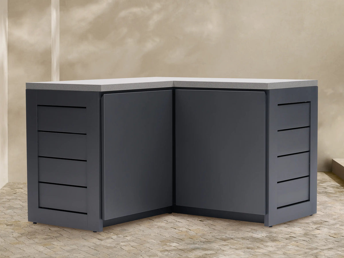 Dark gray L-shaped outdoor aluminum modular kitchen corner cabinet with light gray sintered stone top and grooved side panels.