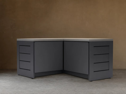 Dark gray L-shaped outdoor aluminum modular kitchen corner cabinet with light gray sintered stone top and grooved side panels.