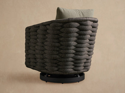 Melbourne Outdoor Swivel Chair. Angled close-up of charcoal woven frame & light gray cushion against a pale wall.