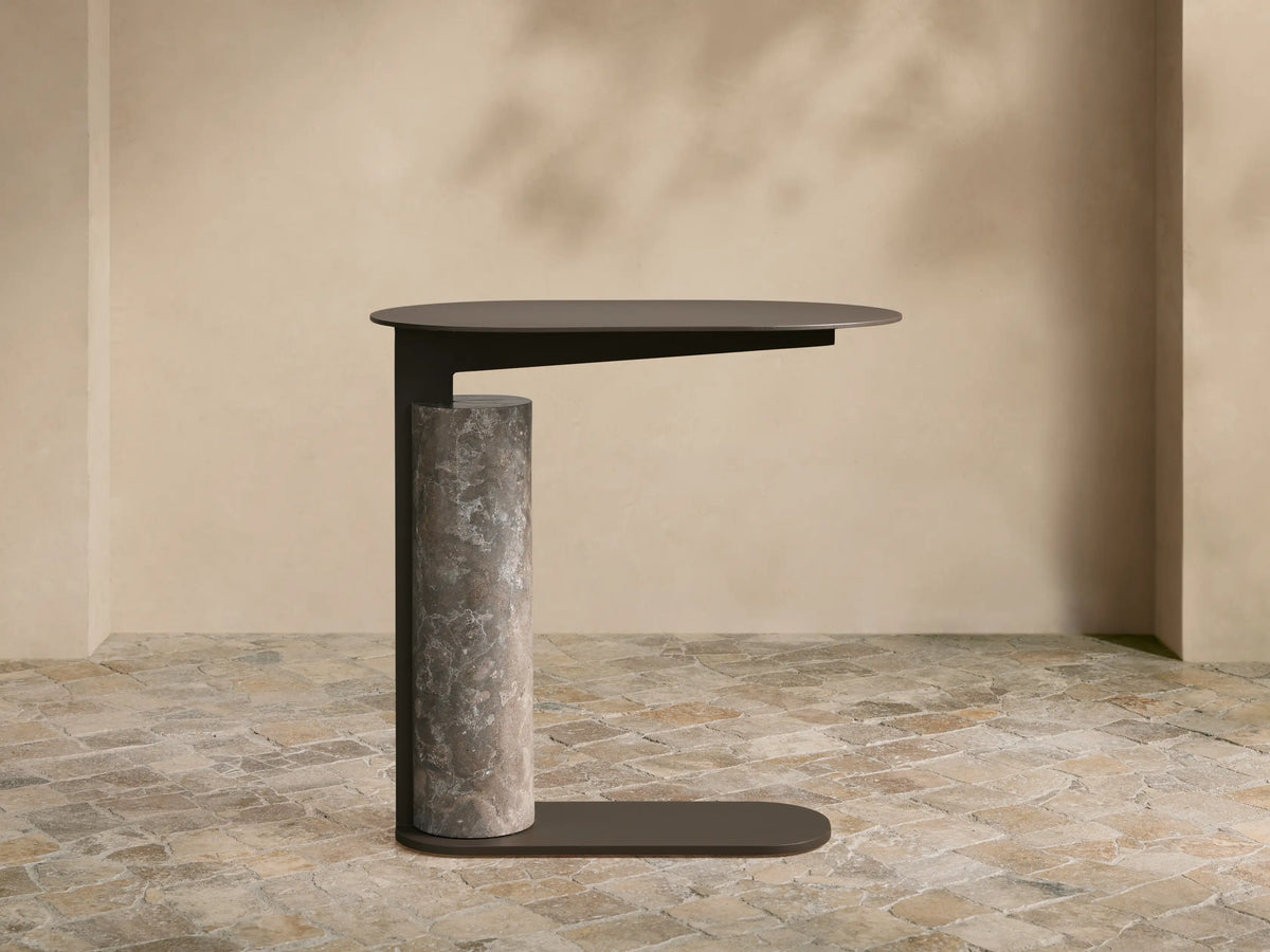 Light gray Minori Outdoor Collection Cover on a patio. It's tailored, rectangular with a rounded top, features a front flap.