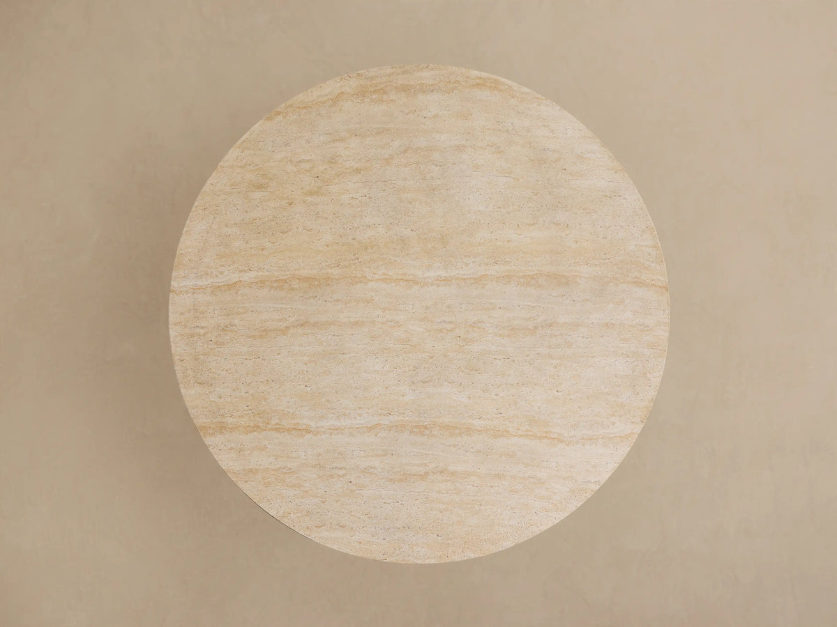 Close-up of Outdoor Round Dining Table with a cream-colored, veined stone top & a dark gray, fluted Launette base.