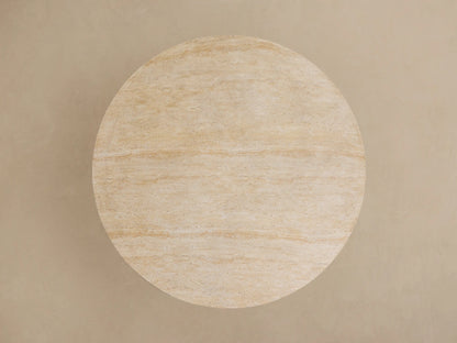 Close-up of Outdoor Round Dining Table with a cream-colored, veined stone top & a dark gray, fluted Launette base.