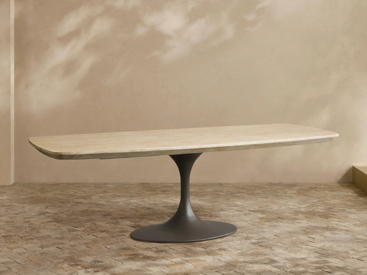 Outdoor Dining Table with light sintered stone top, dark grey conical Launette base, on a patterned tiled patio.