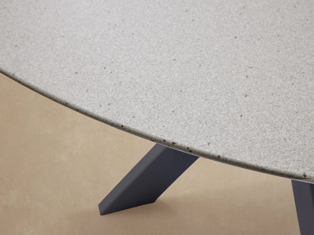 Outdoor Round Dining Table with light gray top and dark gray X-shaped Apex base on a tiled floor.