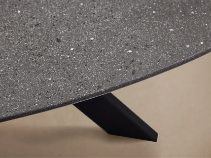 Round dark grey outdoor dining table with a black X-shaped Apex base on a light brown tiled patio.