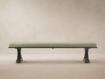 Montego Outdoor Aluminum Dining Bench with dark frame and Eden Sage cushion, against a wooden wall on a patio.