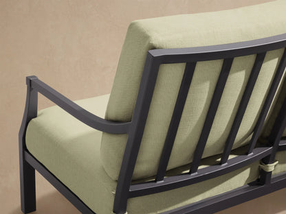 Montego Outdoor Aluminum Sofa with dark gray frame and three light green Eden Sage cushions, on a patio with a shingle wall.