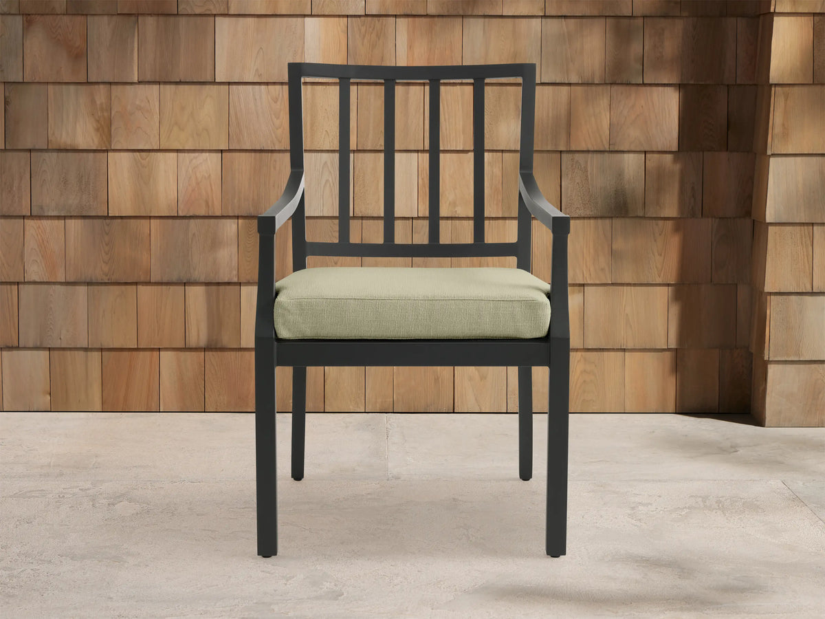 Montego Outdoor Aluminum Dining Arm Chair with dark gray frame, slatted back, armrests, and light sage cushion.