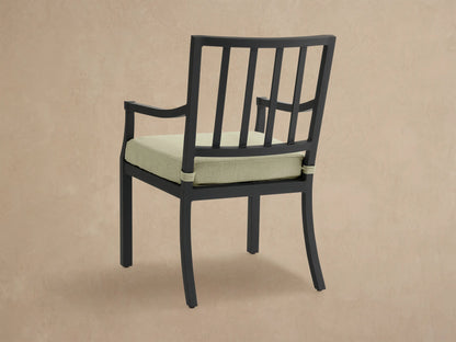 Close-up of Montego black aluminum dining arm chair with light green Eden Sage cushion, showing armrest and back.