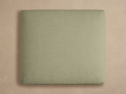 Montego Outdoor Aluminum Ottoman, close-up. Eden Sage fabric cushion with woven texture, resting on a black aluminum frame.