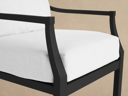 Montego Outdoor Aluminum Lounge Chair, dark gray frame, white cushions, front view. Set against a wooden wall.