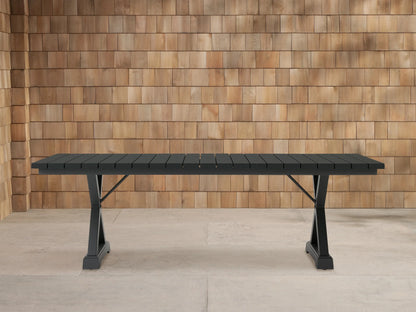 Dark gray Montego Outdoor Aluminum Dining Table with rectangular slatted top and A-frame legs, on a light patio.