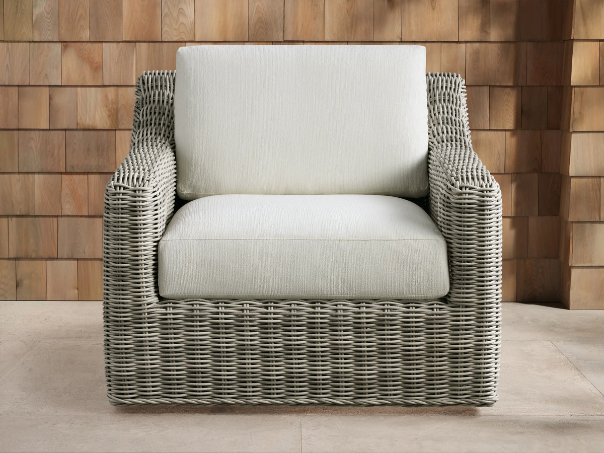 Light gray Montauk Outdoor Collection Cover on a chair, front view, with a vertical zipper, outdoor patio background.
