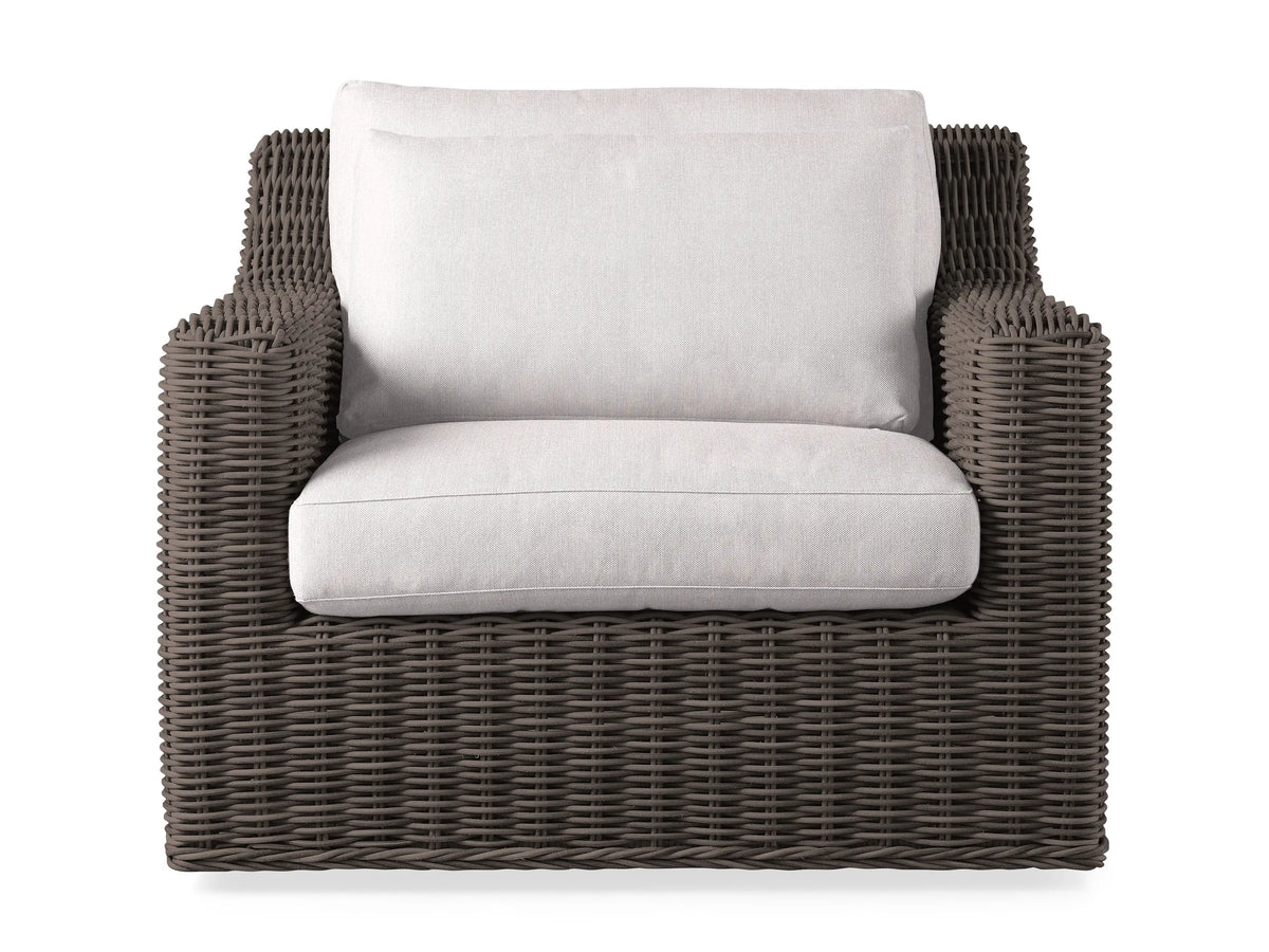 Front view of a Dry Bark Montauk Outdoor Swivel Chair with light cream cushions, featuring a woven resin wicker frame.