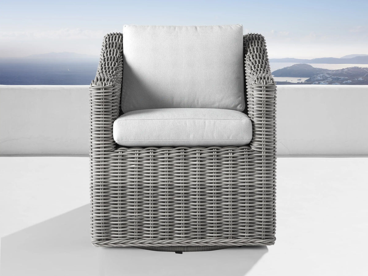Pale grey Montauk Outdoor Water-Repellent Replacement Cushions: seat & backrest, in a grey wicker chair on an outdoor patio.