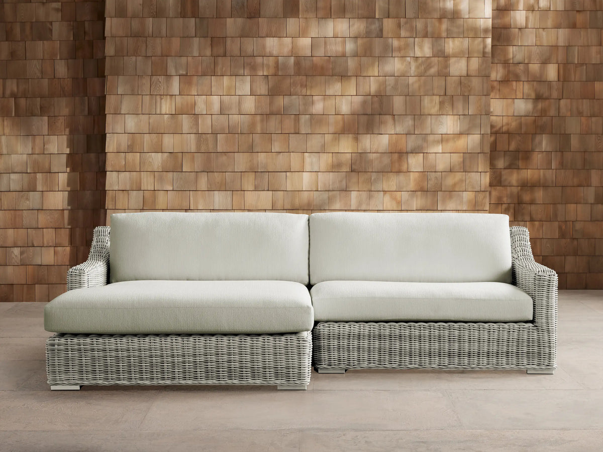 Front view of a light gray woven resin wicker Montauk Outdoor Two-Piece Sectional with pale sage cushions.