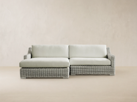 Front view of a light gray woven resin wicker Montauk Outdoor Two-Piece Sectional with pale sage cushions.