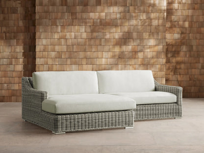 Front view of a light gray woven resin wicker Montauk Outdoor Two-Piece Sectional with pale sage cushions.