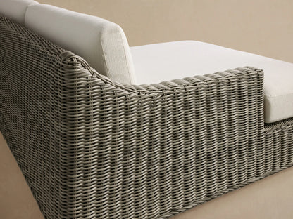 Front view of the gray woven Montauk Outdoor Two-Piece Sectional with light cream cushions and a right-arm facing chaise.