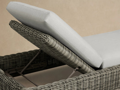 Side profile of a gray woven Montauk Outdoor Chaise with light gray cushions and an elevated adjustable backrest.