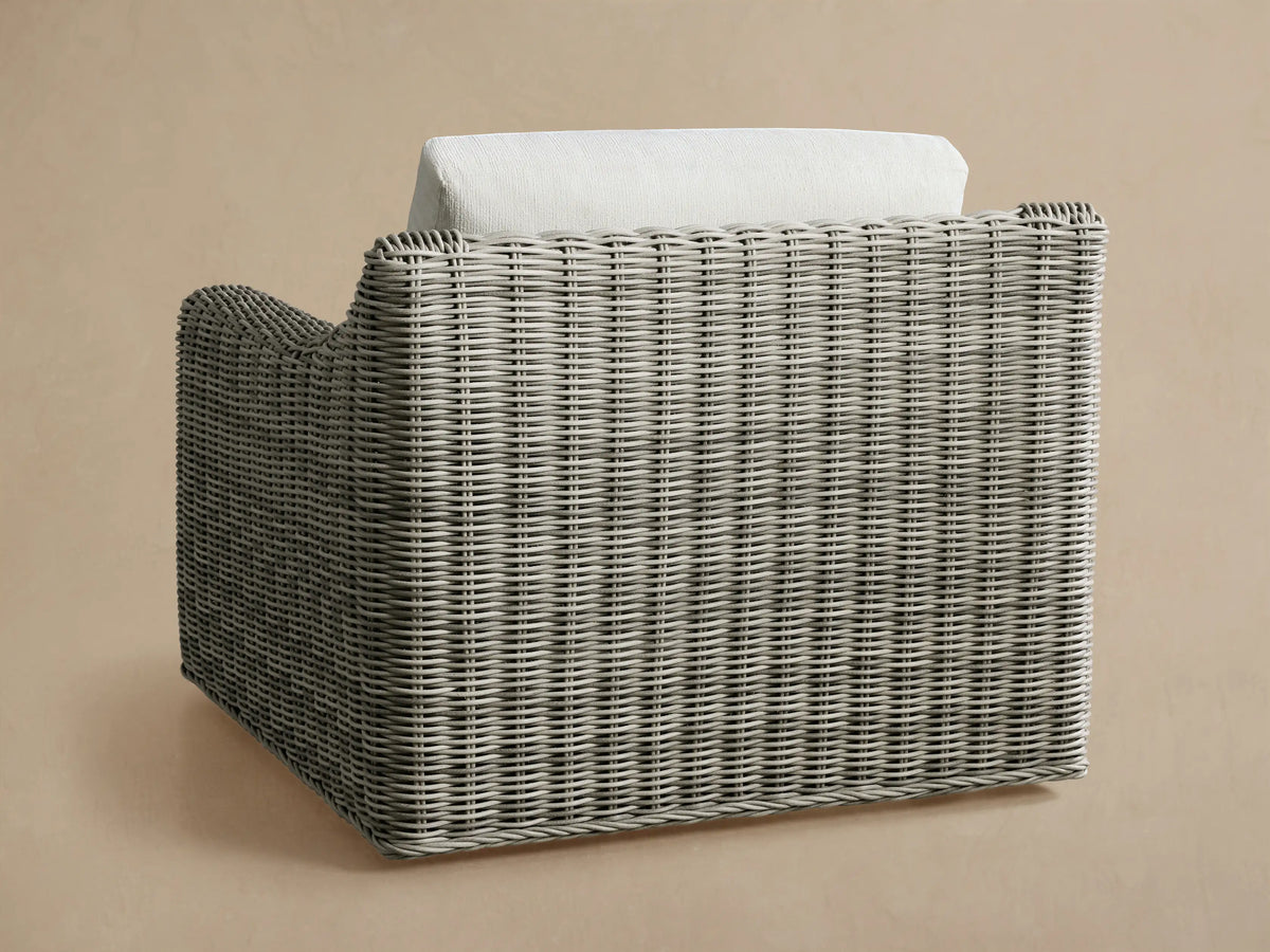 Close-up of the Vista Grey Montauk Outdoor Swivel Chair, highlighting its woven resin wicker and off-white cushions.