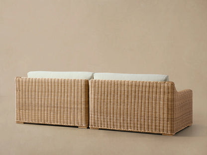 Close-up of Montauk Outdoor Two-Piece Sectional, showing light brown handwoven resin wicker with cream cushions.