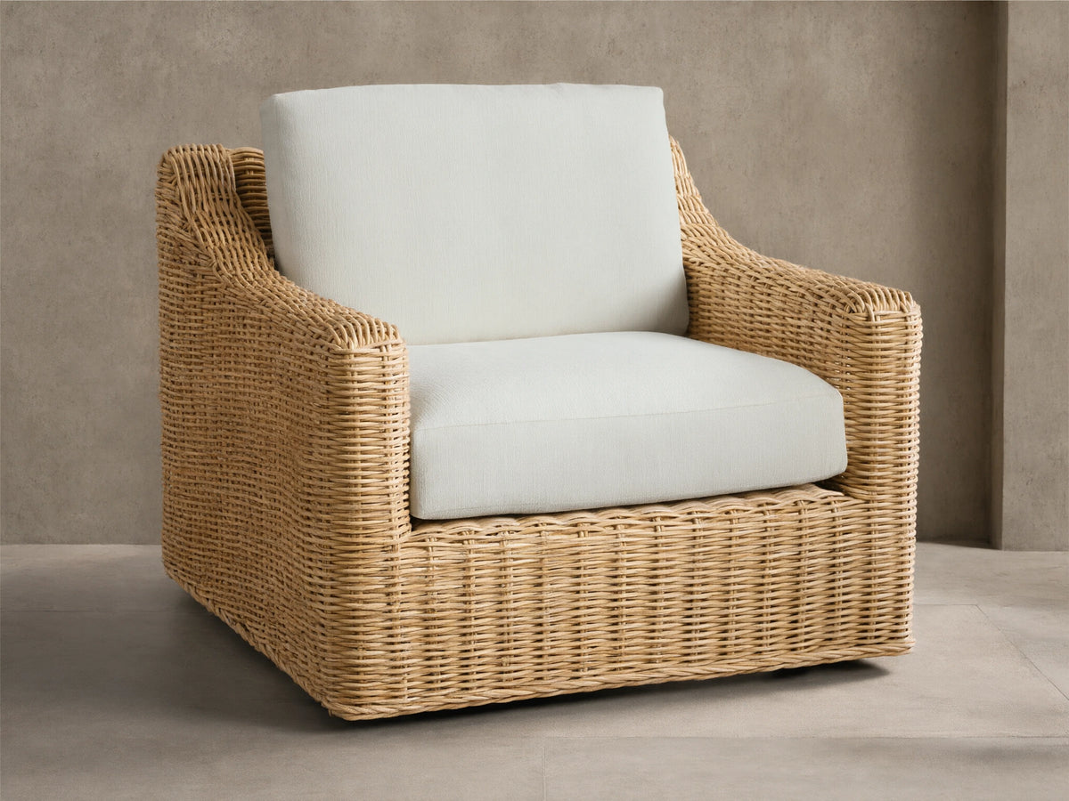 Montauk Outdoor Swivel Chair, light tan woven resin wicker with cream cushions, viewed from front-right on a patio.