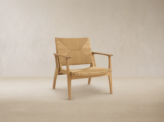 Mustique Outdoor Lounge Chair, light golden teak frame with natural woven wicker seat & back, front-facing on tiled patio.