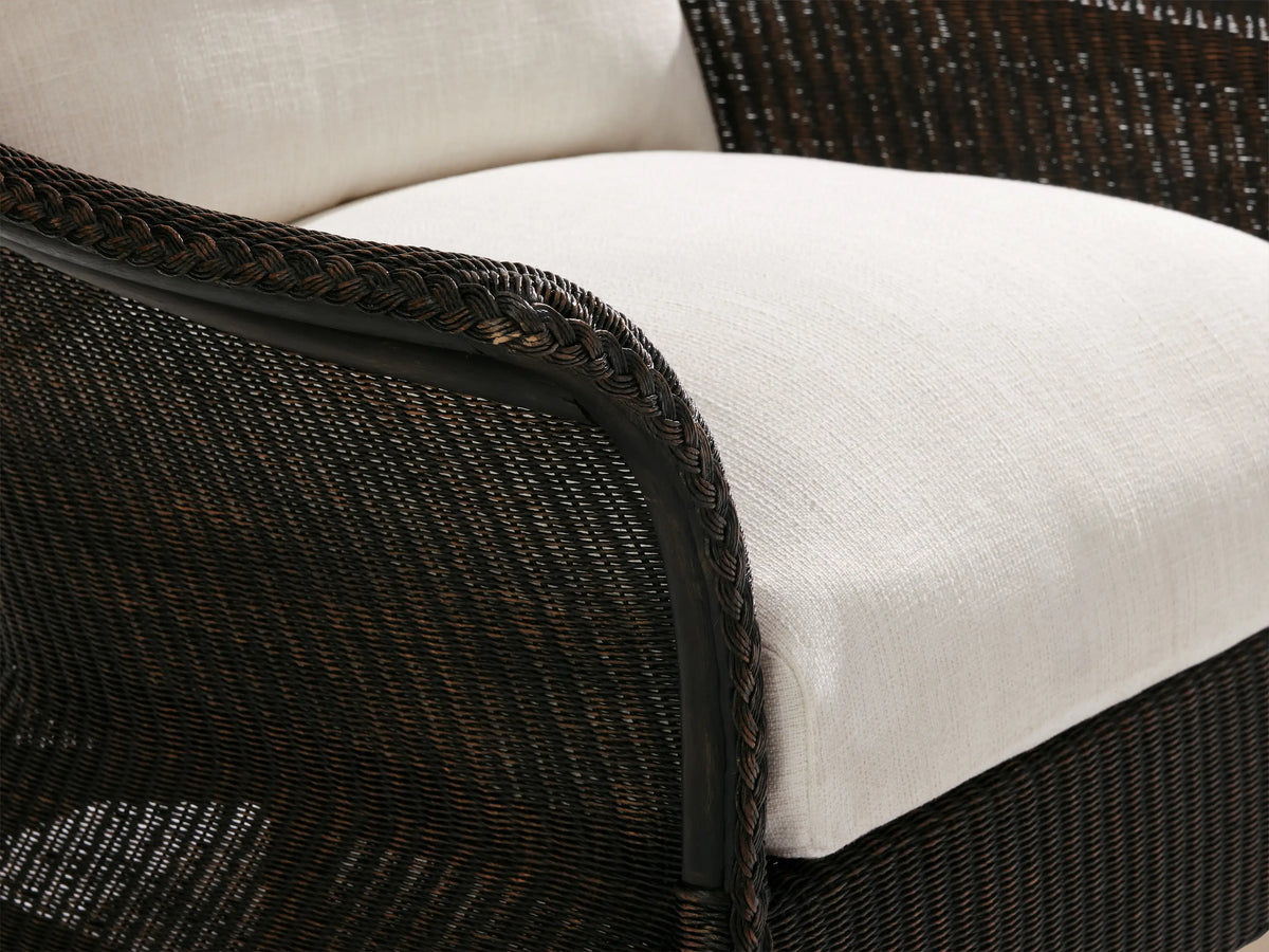 Nantucket Sunroom Lounge Chair with dark brown woven rattan frame, curved arms, and two plush white cushions, on a tiled floor.