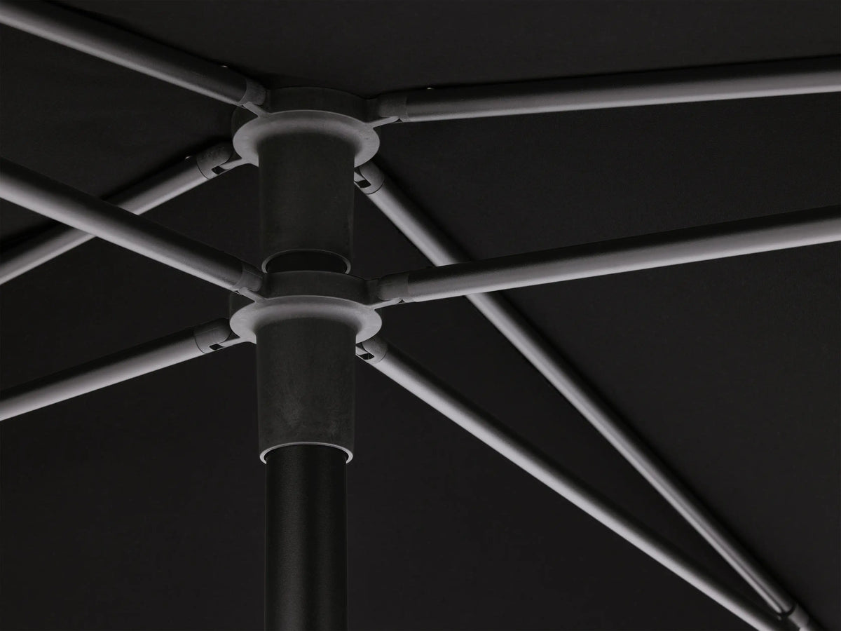 Angled close-up of the black Nata Outdoor Square Umbrella canopy, showing its taut fabric and a silver central hub.