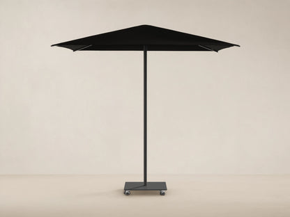 Black Nata Outdoor Square Umbrella with a square canopy, central pole, and wheeled base, against a tan wall and stone floor.