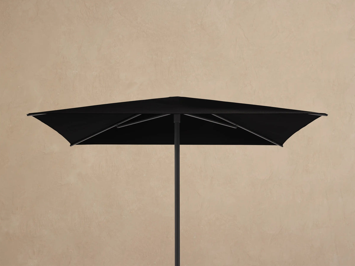 Underside view of a Nata Outdoor Square Umbrella showing its black canopy and dark grey powder-coated aluminum frame.