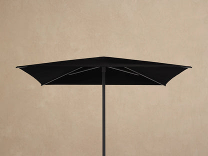 Underside view of a Nata Outdoor Square Umbrella showing its black canopy and dark grey powder-coated aluminum frame.